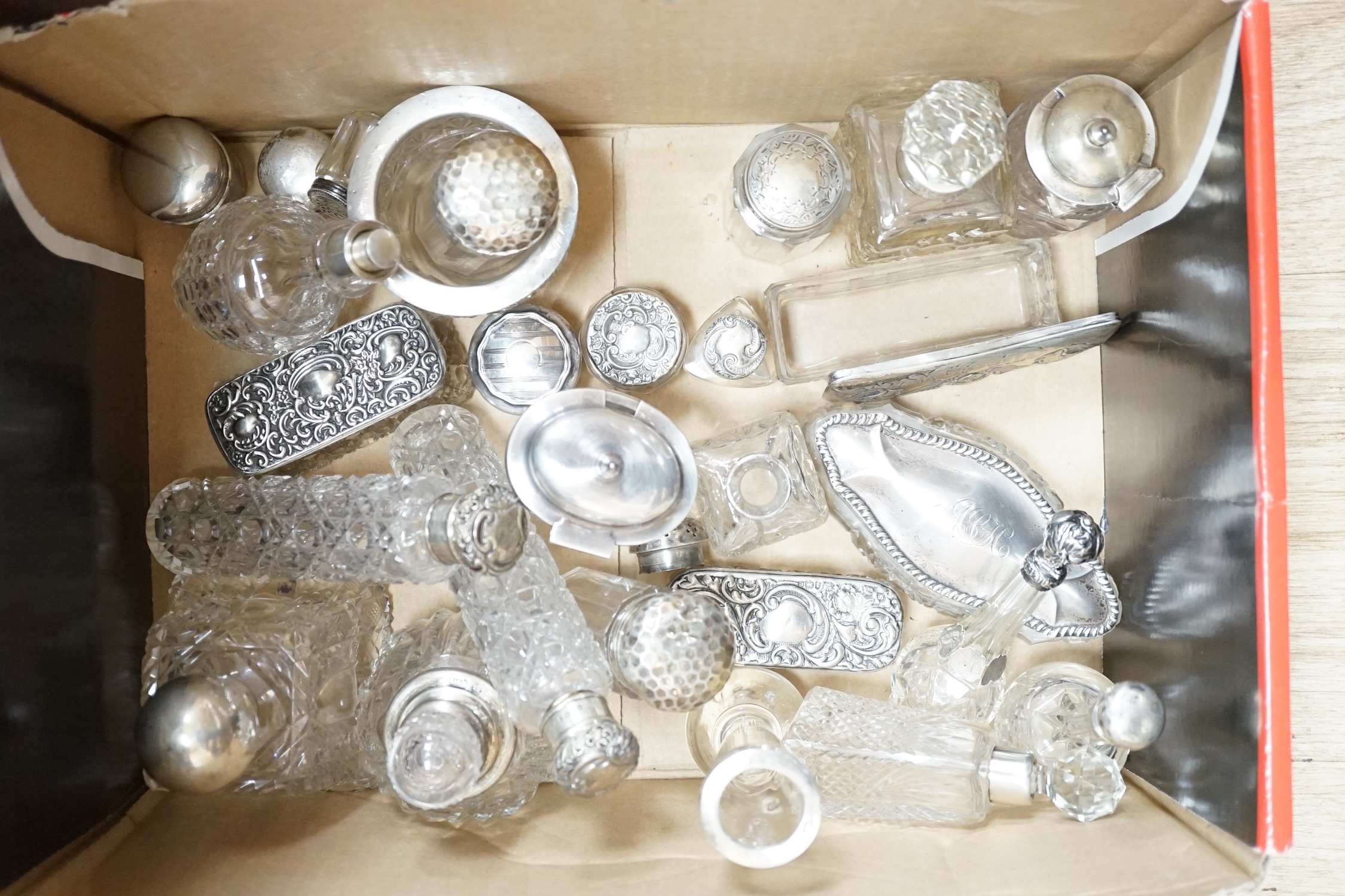 A collection of mainly early 20th century silver mounted glass toilet jars, scent bottles, condiments etc. largest a pair, London, 1895, 15.8cm. Condition - poor to fair